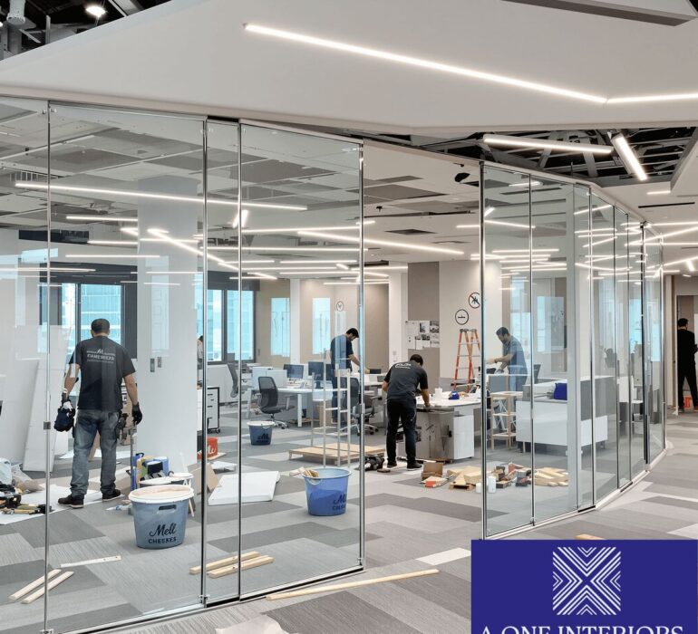 Workers installing partitions and lighting in a modern office under construction with sleek, professional design in a contemporary commercial space.
